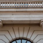 Fachada de prédio público neoclássico com colunas e sacada, vista durante o dia