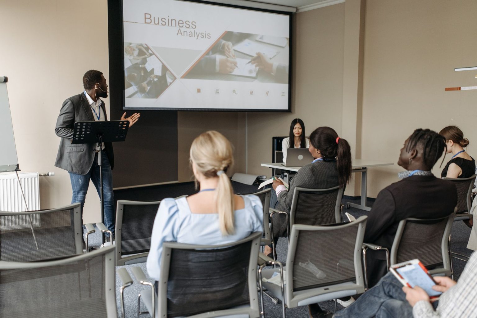 Participantes acompanham uma apresentação sobre negócios em uma sala de conferências.