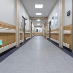 Corredor interno de uma unidade de saúde, com portas de atendimento e ambiente limpo e vazio.