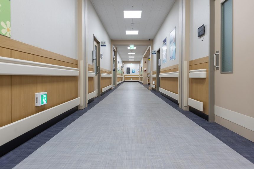 Corredor interno de uma unidade de saúde, com portas de atendimento e ambiente limpo e vazio.